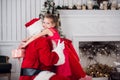 Holidays, celebration, childhood and people concept - smiling little girl hugging with santa claus over christmas tree Royalty Free Stock Photo