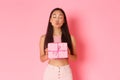 Holidays, celebration and lifestyle concept. Lovely and silly pretty asian girl receiving wrapped gift, close eyes and Royalty Free Stock Photo