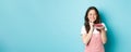 Holidays and celebration. Smiling birthday girl celebrating, looking dreamy at cake with candle, making wish, wants to Royalty Free Stock Photo