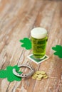 Glass of green beer, horseshoe and gold coins Royalty Free Stock Photo