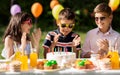 Happy kids with cake on birthday party at summer Royalty Free Stock Photo