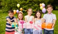 Happy kids with gifts on birthday party at summer Royalty Free Stock Photo