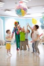 Holidays, childhood and celebration concept - several kids having fun and jumping on birthday party in entertainment
