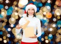 Smiling woman in santa hat opening christmas gift Royalty Free Stock Photo