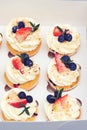 Holidays cupcakes with strawberry and blueberry, close up. Gift box with sweets. Set of different delicious cupcakes. Delivery.