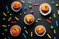 Holidays, decorations and party concept - Halloween cupcakes and candies on black background Royalty Free Stock Photo