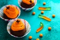 Holidays, decorations and party concept - Halloween cupcakes and candies on green background Royalty Free Stock Photo