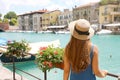 Holidays in Europe. Back view of beautiful fashion girl enjoying visiting Lake Garda. Summer vacations in Italy