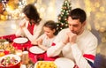 Family praying before meal at christmas dinner Royalty Free Stock Photo