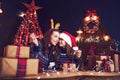 Holidays, family and people concept. Happy mother and little girl in santa helper hat with sparklers in hands, gift Royalty Free Stock Photo