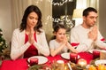 Family praying before meal at christmas dinner Royalty Free Stock Photo