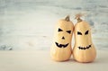 Holidays Halloween image. Cute and scary face of pumpkin over wooden white table