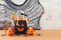 Holidays image of Halloween. Pumpkins, bats, treats, paper gift bag over wooden table