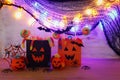 Holidays image of Halloween. Pumpkins, bats, treats, paper gift bag over wooden table