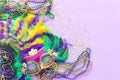 Holidays image of mardi gras masquarade, venetian mask and fan over purple background. view from above