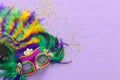 Holidays image of mardi gras masquarade, venetian mask and fan over purple background. view from above