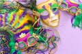 Holidays image of mardi gras masquarade, venetian mask and fan over purple background. view from above