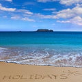 HOLIDAYS insctiption under the sun drawing on wet beach sand wit Royalty Free Stock Photo