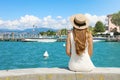 Holidays in Italy. Back view of beautiful girl sitting on wall enjoying view of Sirmione harbour on Lake Garda. Summer vacations