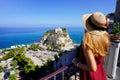 Holidays in Italy. Back view of beautiful young woman enjoying view of Tropea village from terrace on Coast of the Gods, Calabria