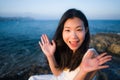 Holidays lifestyle portrait of young Asian woman by the  sea -  happy and beautiful Korean girl  enjoying beach vacation trip Royalty Free Stock Photo