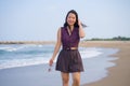 Holidays lifestyle portrait of young happy and attractive Asian Korean woman walking playful on beach enjoying the sea relaxed and Royalty Free Stock Photo