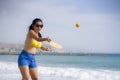 Holidays lifestyle portrait of young happy and cute Asian Japanese woman playing paddle ball holding racquet in the beach enjoying Royalty Free Stock Photo