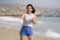 Holidays lifestyle portrait of young happy and cute Asian Korean woman playing paddle ball holding racquet in the beach enjoying Royalty Free Stock Photo