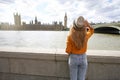 Holidays in London. Back view of traveler girl visiting London City with Westminster palace and bridge on Thames river and famous Royalty Free Stock Photo