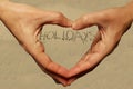 Holidays by the sea on the sandy beach hands fingers like heart love background