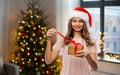 Teenage girl in santa hat opening christmas gift Royalty Free Stock Photo