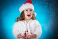 holidays, presents, christmas, childhood concept - smiling little girl over blue background. Royalty Free Stock Photo