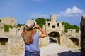 Holidays in Rhodes, Greece. Back view of traveler girl enjoying view of the Gate of Saint Paul in Rhodes fortifications city,