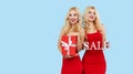 Holidays sales. Happy Women with gift boxes in red dresses on blue background, Royalty Free Stock Photo