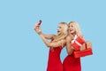 Holidays sales. Happy Women with gift boxes in red dresses on blue background, Royalty Free Stock Photo