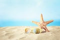 Holidays. sand beach, sunglasses and starfish in front of summer sea background with copy space Royalty Free Stock Photo