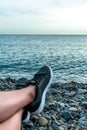 Holidays at sea, vacation and travel concept-young girl resting lying on the sea, legs in sneakers close-up, summer adventures, Royalty Free Stock Photo