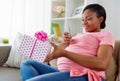 African pregnant woman with smartphone and gift Royalty Free Stock Photo