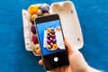 Holidays, tradition, technology and people concept - close up of man hands with smartphone taking picture of colored easter eggs