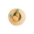 Holidays tropical concept. Pineapple fruits in straw hat on white background. Flat lay, top view.