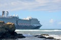 Holland America Line Cruise ship leaving port with rocks in Foreground