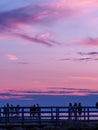 Holland, Michigan - 8/10/19: silouhette of people on pier enjoying pink sunset Royalty Free Stock Photo