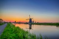 Holland Traveling. Line of Distant Traditional Dutch Windmills in the Village of Zaanse Schans at Daytime in the Netherlands Royalty Free Stock Photo