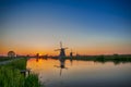 Holland Traveling. Line of Distant Traditional Dutch Windmills in the Village of Zaanse Schans at Daytime in the Netherlands Royalty Free Stock Photo