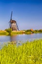 Holland Traveling. Traditional Romantic Dutch Windmill in Kinderdijk Village in the Netherlands With Water Canal Royalty Free Stock Photo