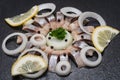 Hollandse Nieuwe- Traditional Dutch Food. Soused raw Herring soaked in mild marinade. Garnished with Lemon, Onion and Parsley Royalty Free Stock Photo