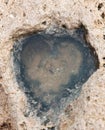 A hollow in the stone in the form of a heart filled with water Royalty Free Stock Photo