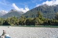 Hollyford River flowing between mountains over flat wide stony riverbed
