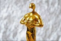 Hollywood Golden Oscar Academy award statue in medical mask on silver background with copy space. Success and victory concept. Osc