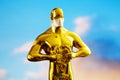 Hollywood Golden Oscar Academy award statue in medical mask. Success and victory concept. Oscar ceremony in coronavirus time